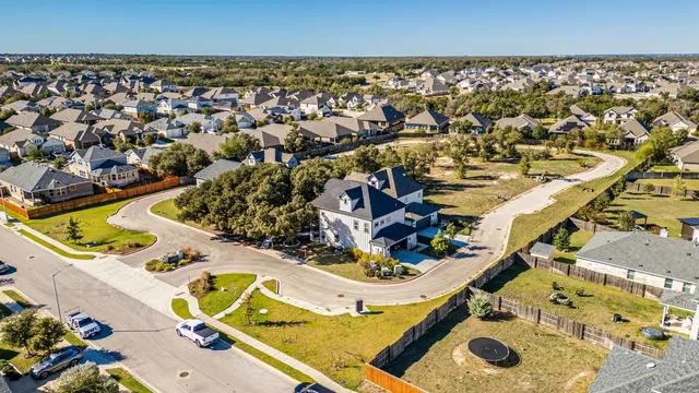 an aerial view of residential houses with yard