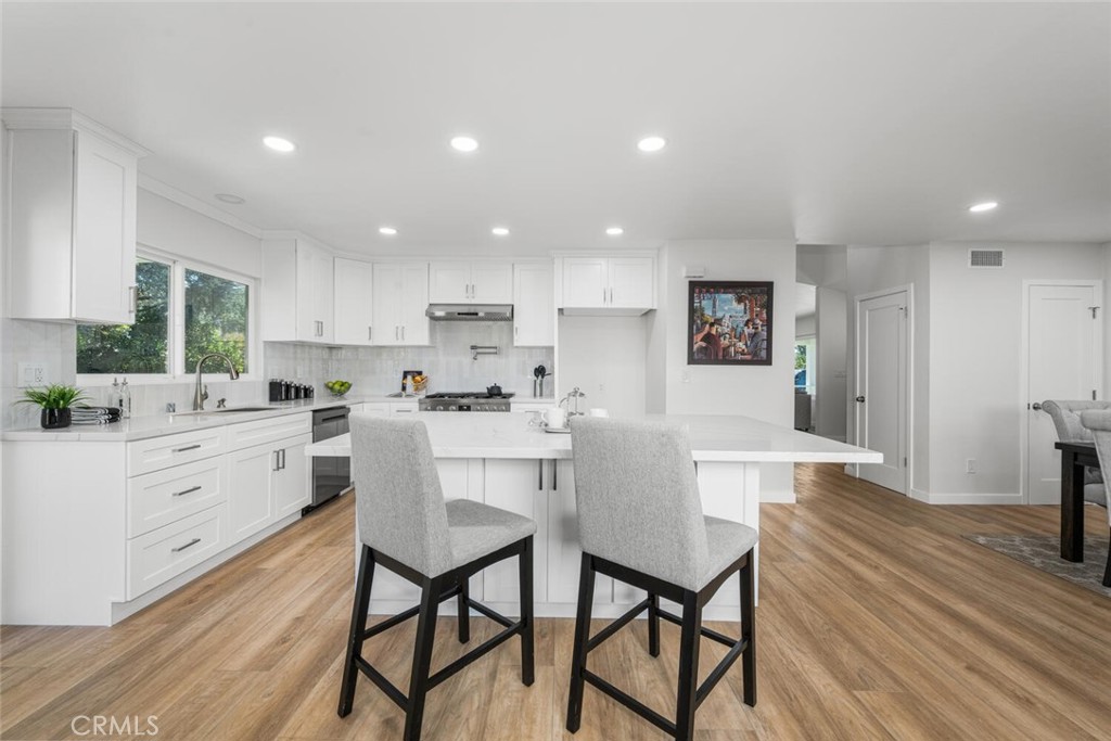 11344 Rochelle Street Los Alamitos, CA 90720 - Photo 12 of 55 a kitchen with stainless steel appliances kitchen island granite countertop a table chairs sink and cabinets