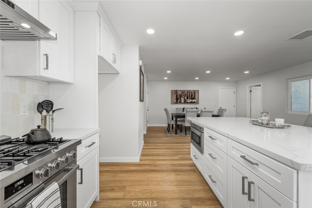11344 Rochelle Street Los Alamitos, CA 90720 - Photo 17 of 55 a large kitchen with stainless steel appliances kitchen island a stove a sink a refrigerator and white cabinets