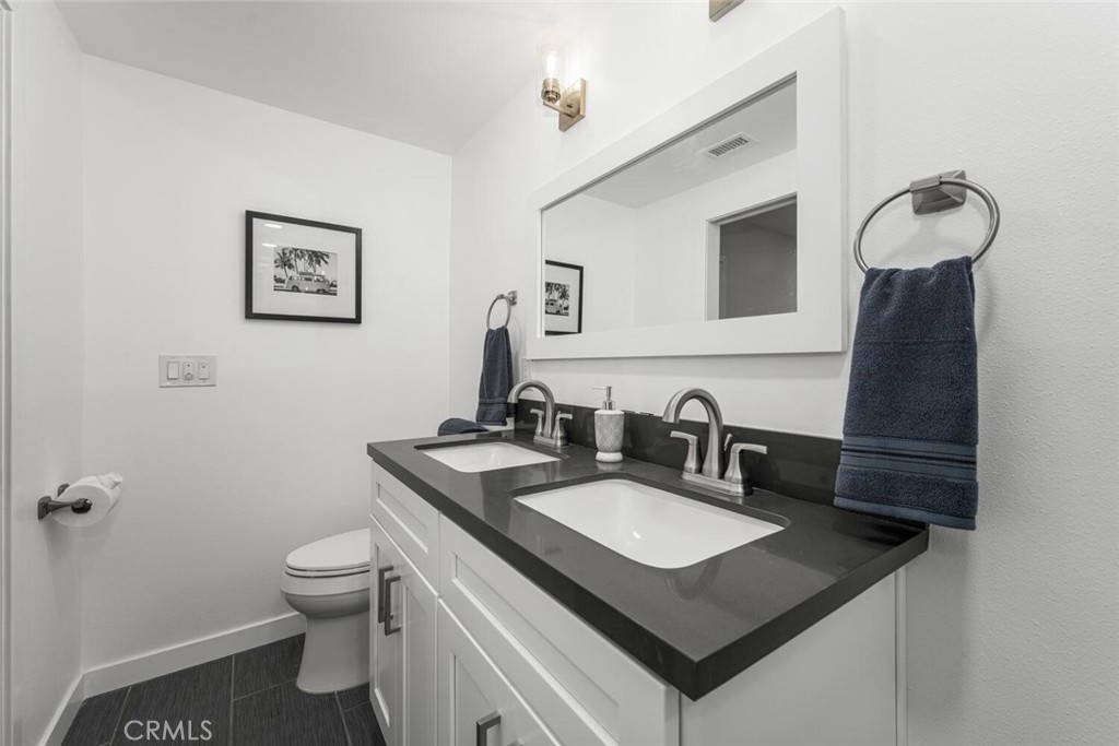 11344 Rochelle Street Los Alamitos, CA 90720 - Photo 26 of 55 a bathroom with a sink toilet and a mirror