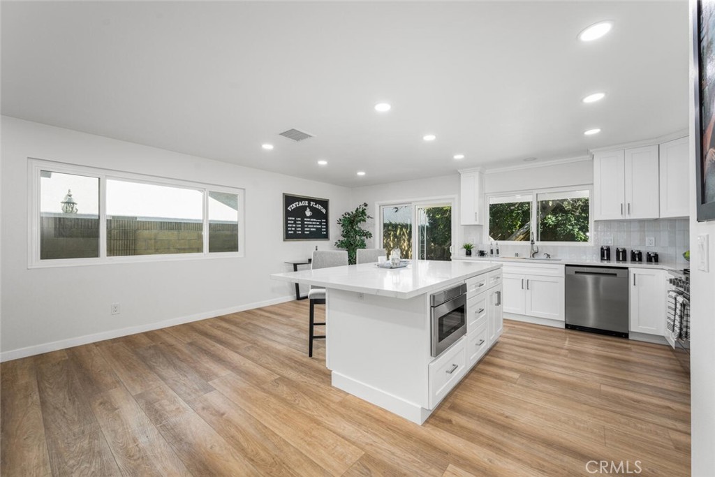 11344 Rochelle Street Los Alamitos, CA 90720 - Photo 8 of 55 a large kitchen with stainless steel appliances granite countertop a large white stove top oven and white cabinets
