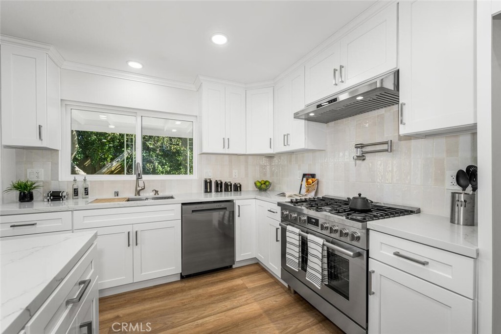 11344 Rochelle Street Los Alamitos, CA 90720 - Photo 9 of 55 a kitchen with stainless steel appliances granite countertop a sink a stove and cabinets
