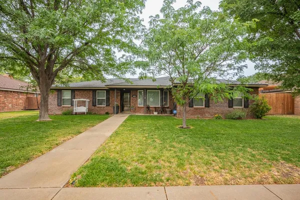 front view of a brick house with a yard
