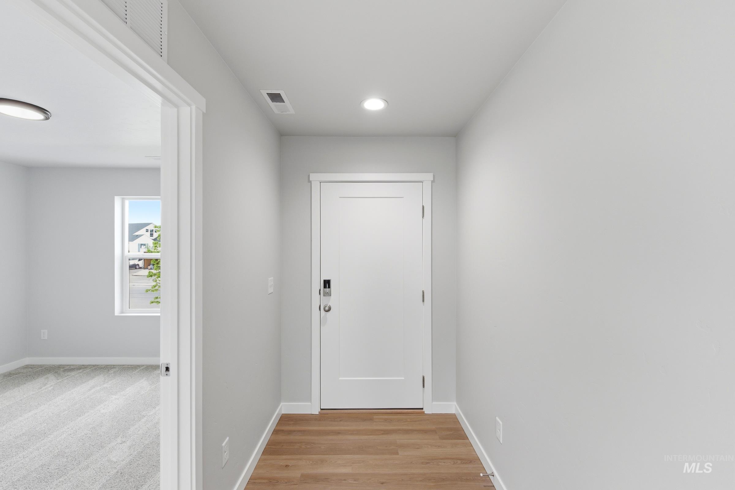 16558 Dunning Way Caldwell, ID 83607 - Photo 2 of 35 Entryway featuring wood-finish flooring, a contemporary white door with smart lock hardware, recessed lighting, and crisp white trim
