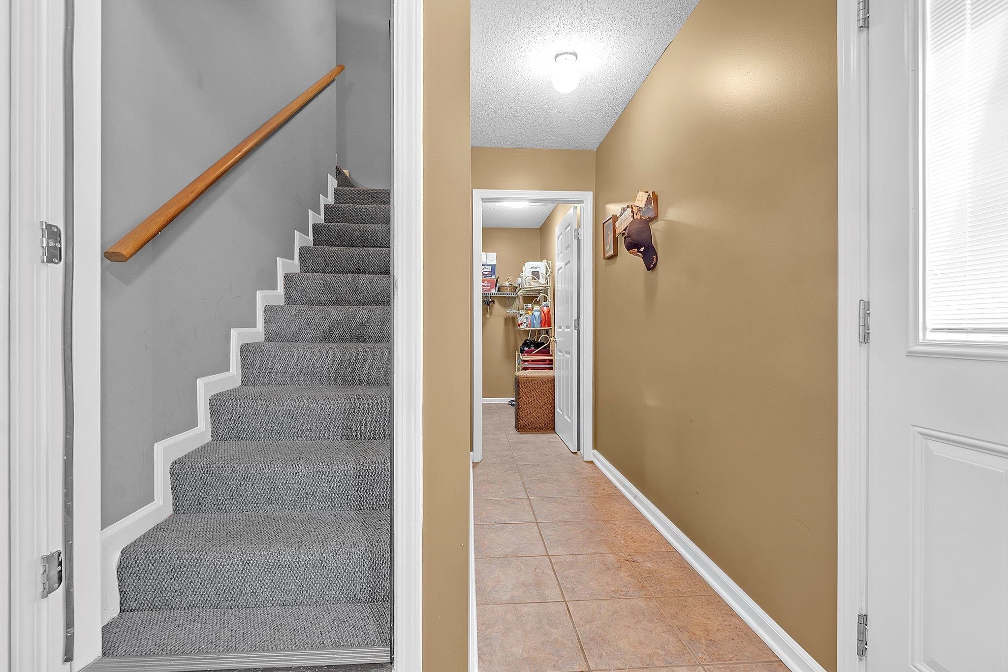4020 Altruria Road Bartlett, TN 38135 - Photo 20 of 25 Carpeted staircase with a wood handrail, presenting a neutral color palette