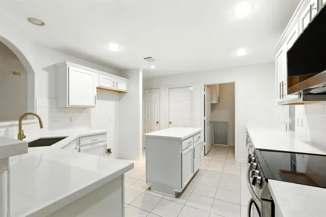 a kitchen with a sink appliances and cabinets
