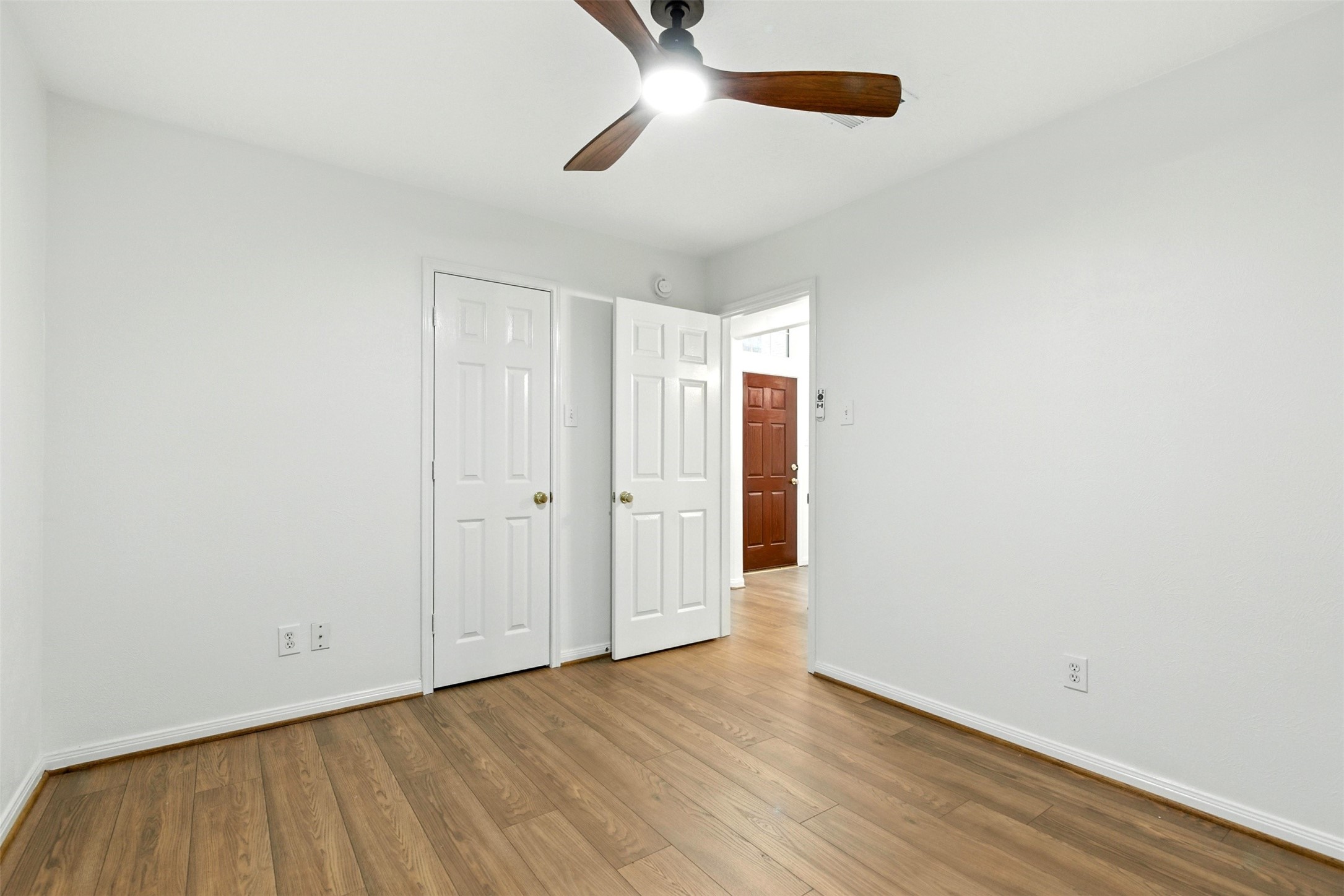 2119 Hannover Way Spring, TX 77388 - Photo 23 of 39 an empty room with wooden floor cabinet and ceiling fan