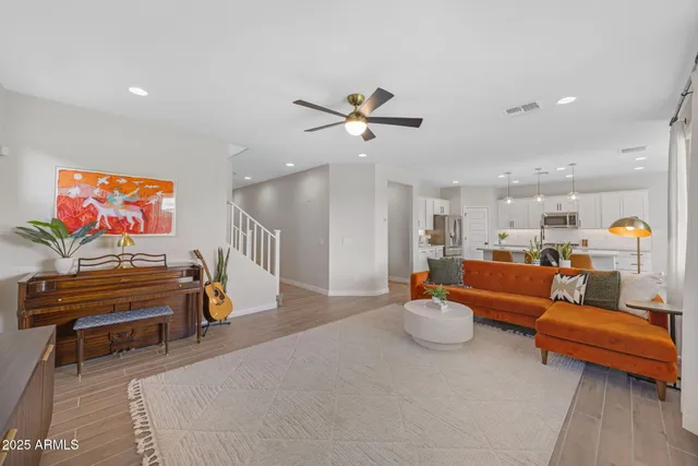 a large kitchen with kitchen island a stove a sink a refrigerator and a dining table with wooden floor