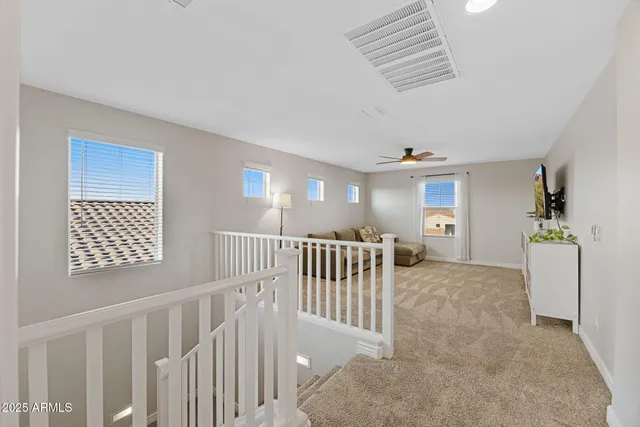 a spacious bedroom with a large bed a flat tv screen and a dresser