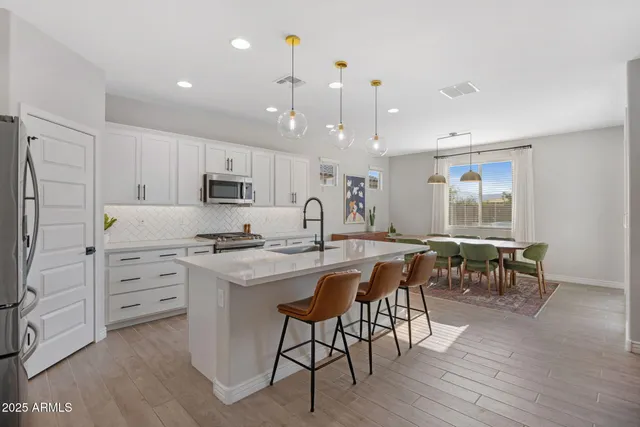 a kitchen with kitchen island granite countertop a table and chairs in it