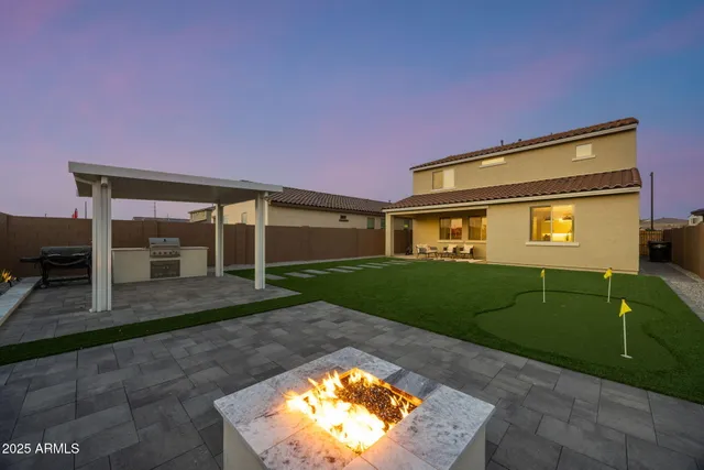 a backyard of a house with table and chairs