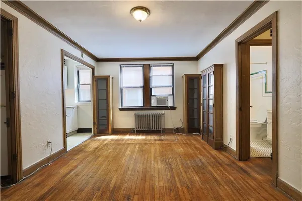a view of a room with wooden floor and a window