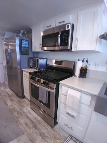 a kitchen with granite countertop a stove and a microwave