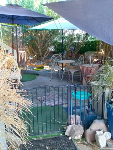 a patio with table and chairs potted plants