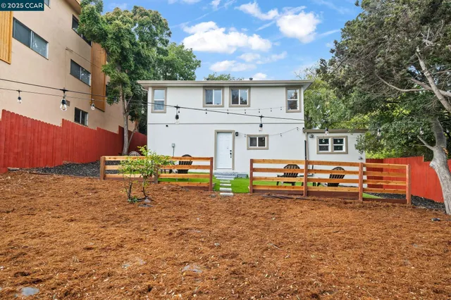 a backyard of a house with barbeque oven table and chairs