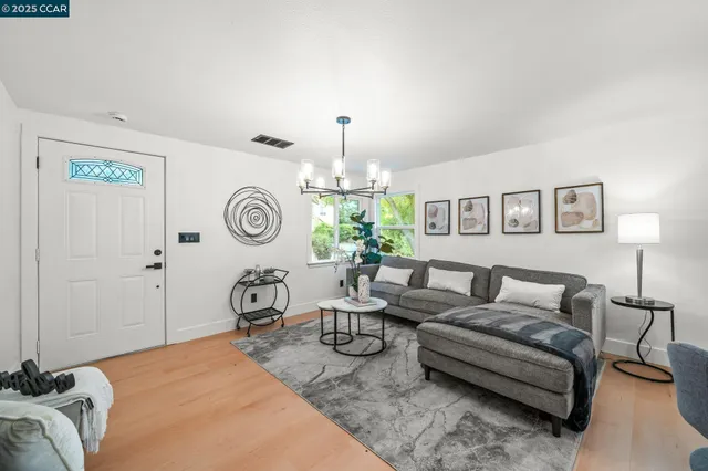 a living room with furniture a table and a chandelier