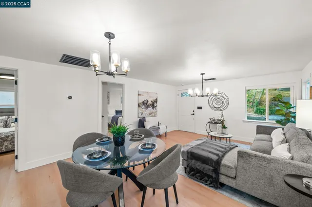 a living room with furniture chandelier and a large window
