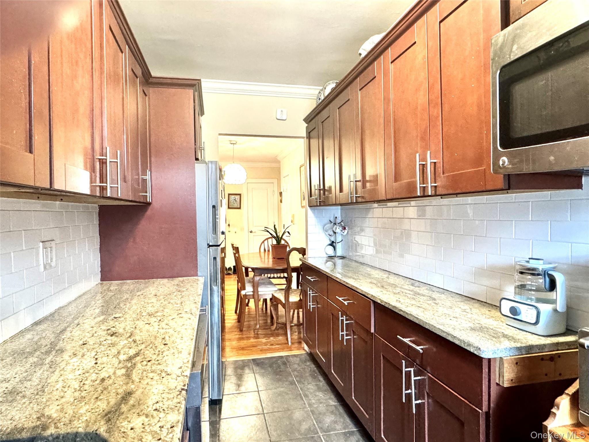 150-25 72nd Road, Unit 4C Queens, NY 11367 - Photo 13 of 16 a kitchen with stainless steel appliances granite countertop a sink stove and cabinets