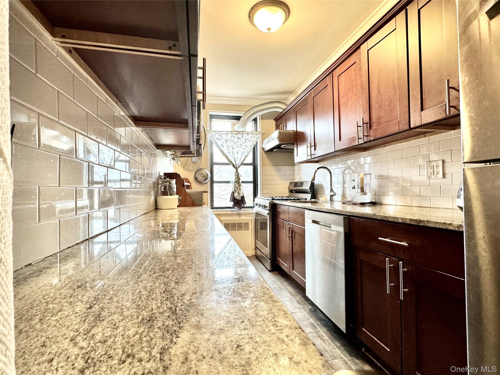 150-25 72nd Road, Unit 4C Queens, NY 11367 - Photo 6 of 16 a kitchen with stainless steel appliances granite countertop a refrigerator and a sink