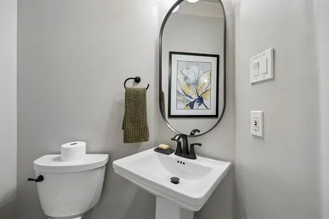 a bathroom with a toilet sink and mirror