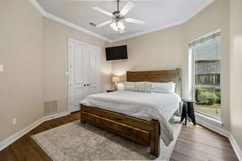 a bedroom with a bed and a flat tv screen on dresser