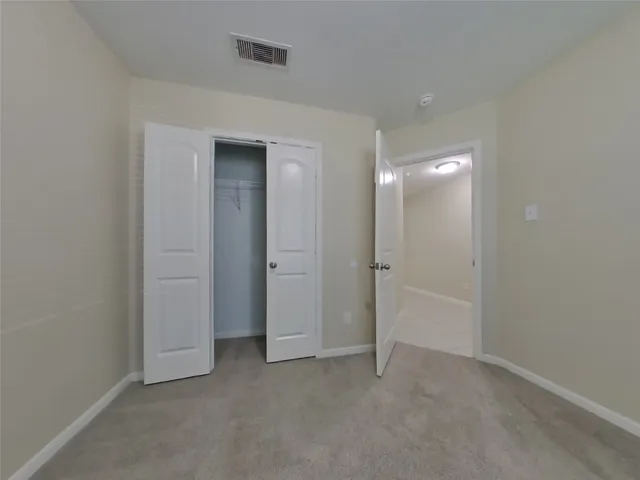 an empty room with closet and a bathroom