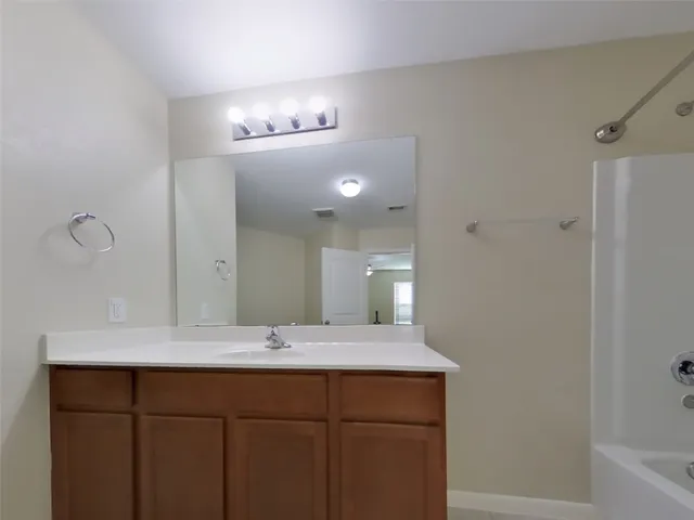 a bathroom with a double vanity sink a mirror and a bathtub
