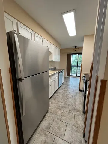 a kitchen with granite countertop a refrigerator a sink and a stove top oven