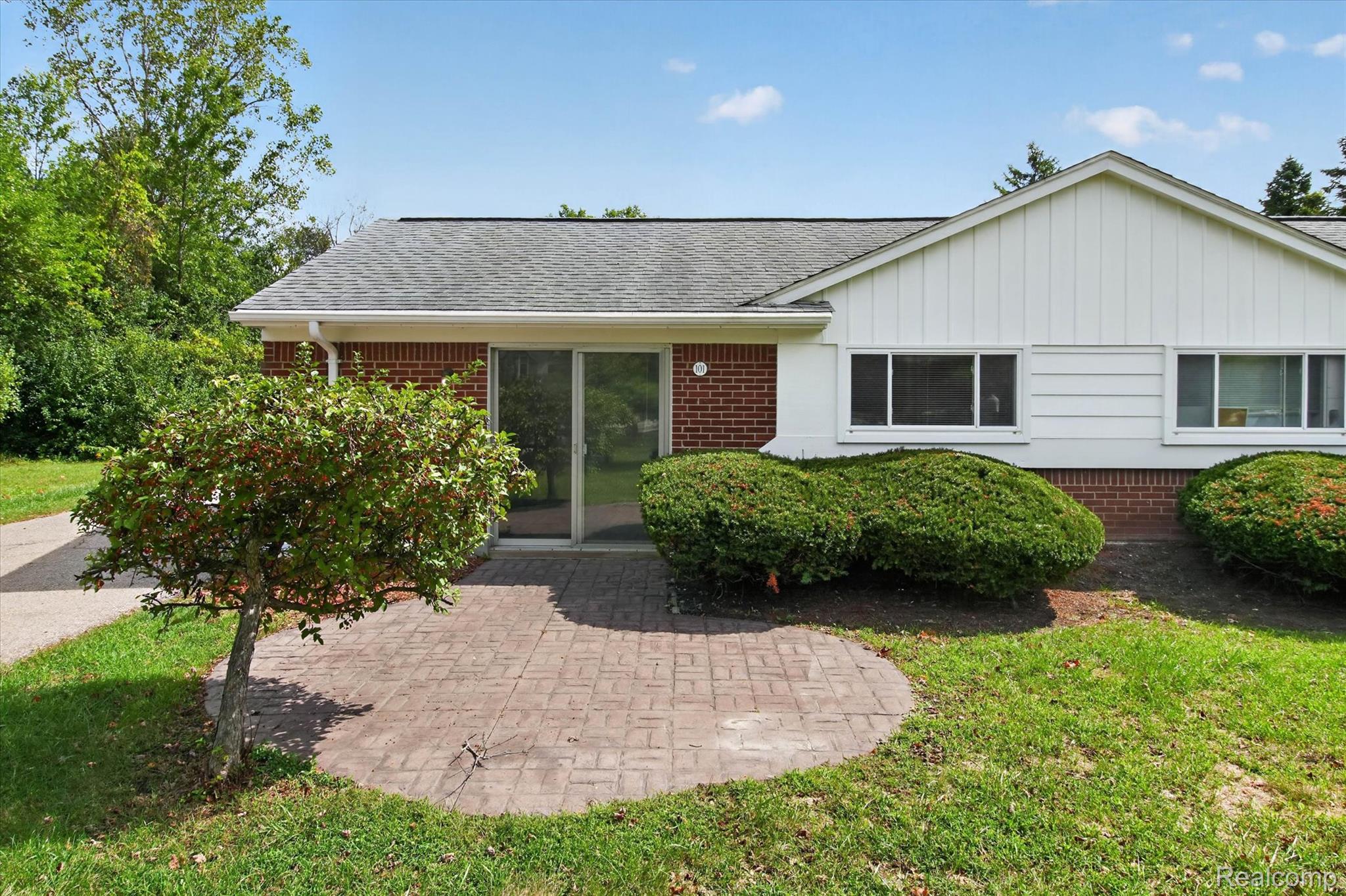 22000 Beck Road, Unit 101 Northville, MI 48167 - Photo 17 of 20 Brick and siding exterior with a shingle roof, featuring an outdoor patio area