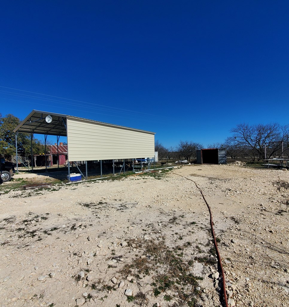 3567 Cave Wells Road, Unit 1721 Fort McKavett, TX 76841 - Photo 5 of 16 a view of a dry yard with a house