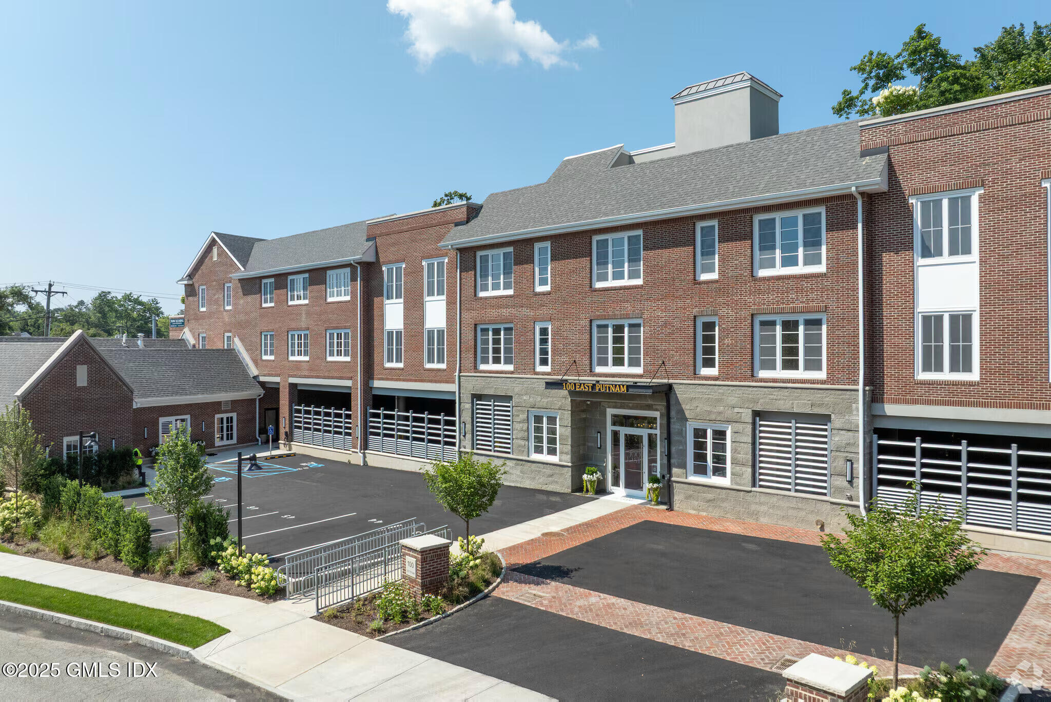 100 East Putnam Avenue, Unit 210 Cos Cob, CT 06807 - Photo 27 of 27 a front view of a residential apartment building with a yard