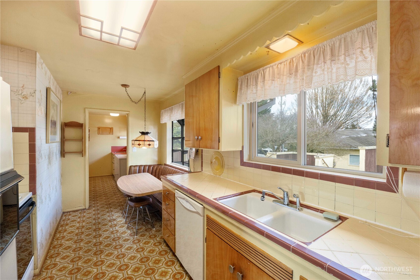 10702 39th Avenue Southwest Seattle, WA 98146 - Photo 12 of 40 a spacious bathroom with a sink a toilet a mirror and a tub