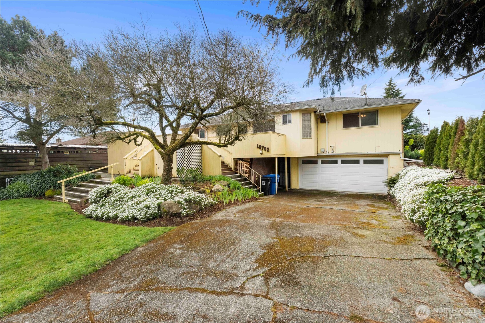 10702 39th Avenue Southwest Seattle, WA 98146 - Photo 31 of 40 a front view of a house with a garden and yard