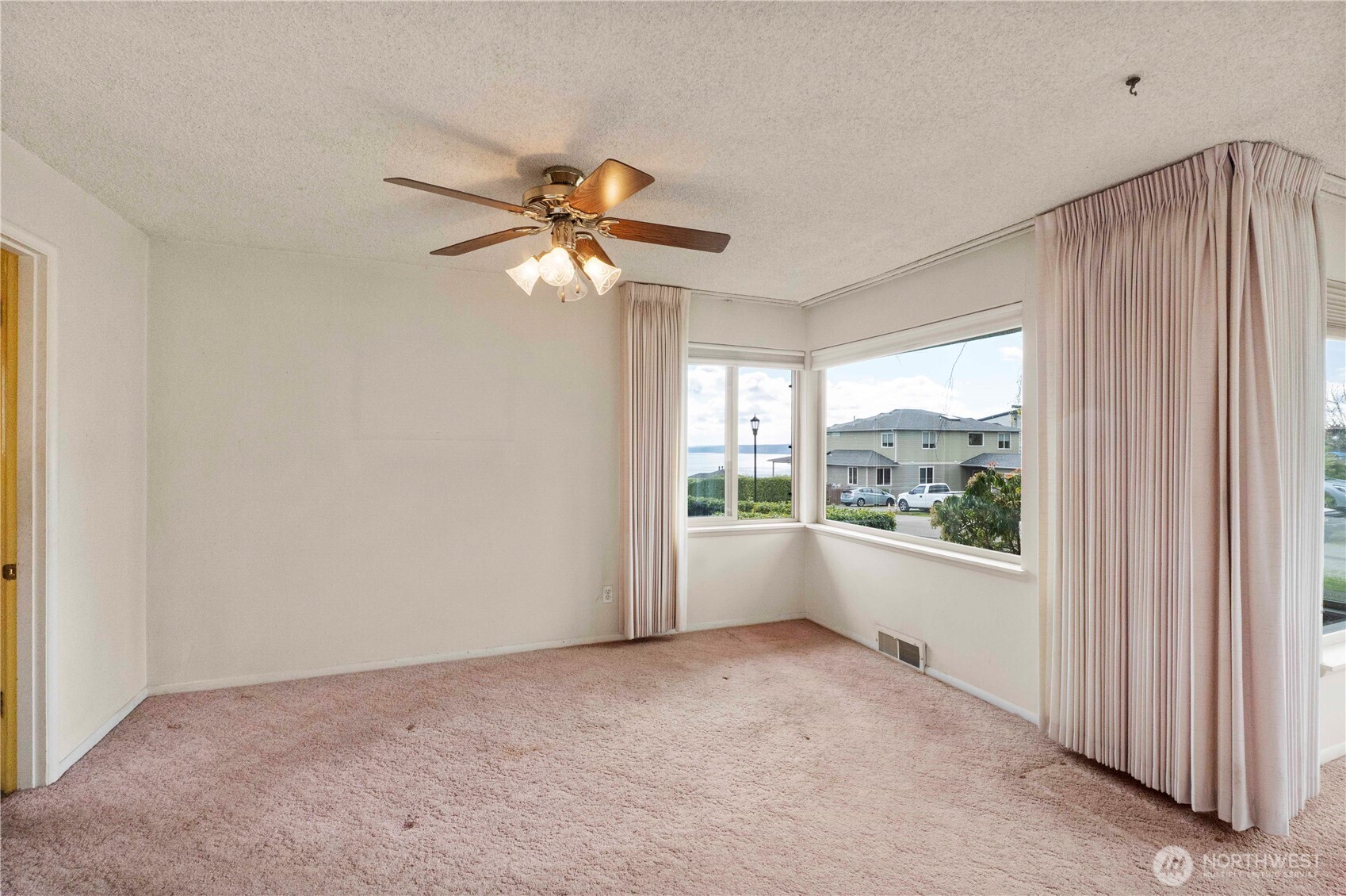 10702 39th Avenue Southwest Seattle, WA 98146 - Photo 9 of 40 an empty room with windows and fan