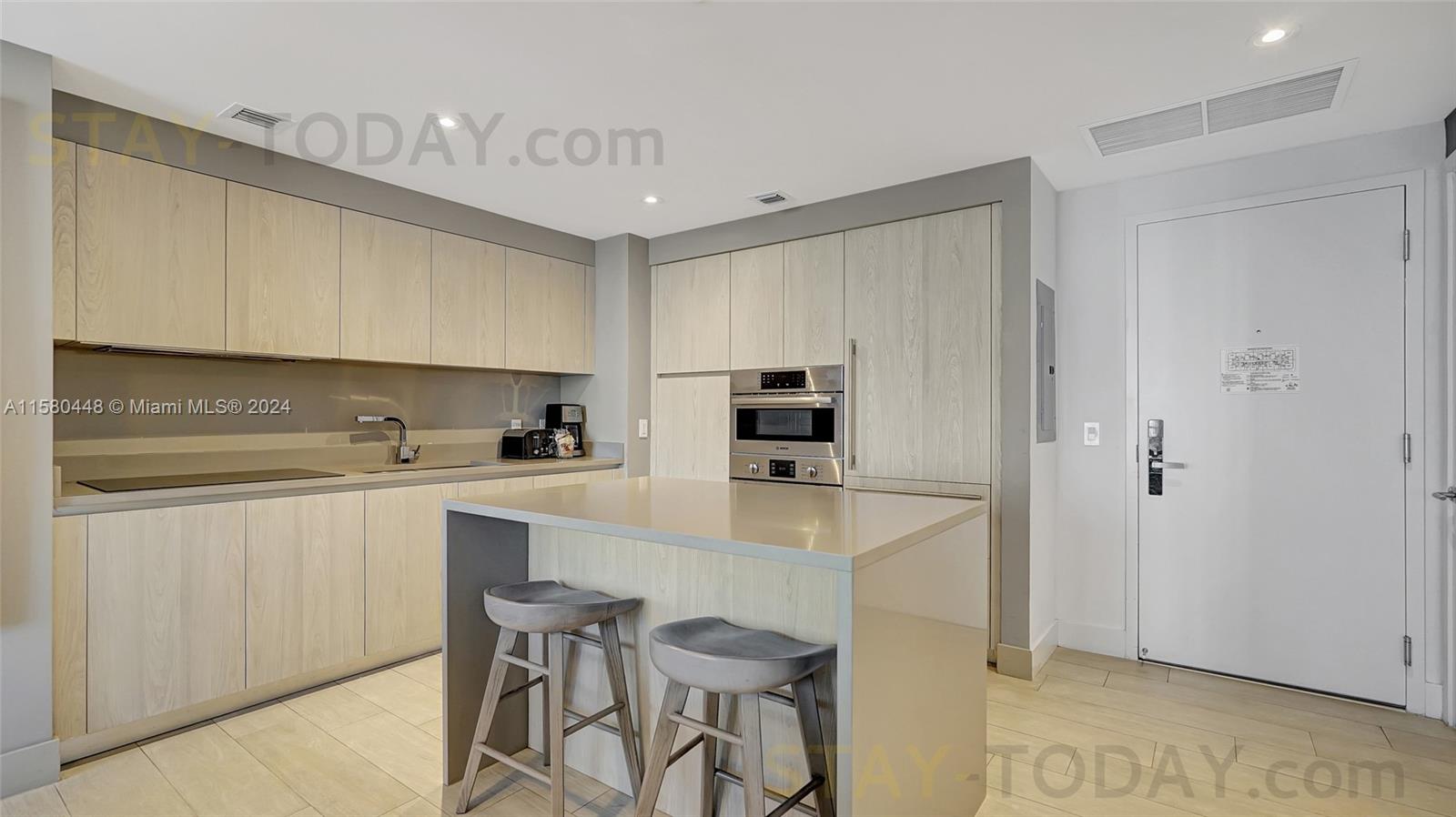 4010 South Ocean Drive, Unit R805 Hollywood, FL 33019 - Photo 11 of 36 a kitchen with stainless steel appliances a stove a sink cabinets and a refrigerator