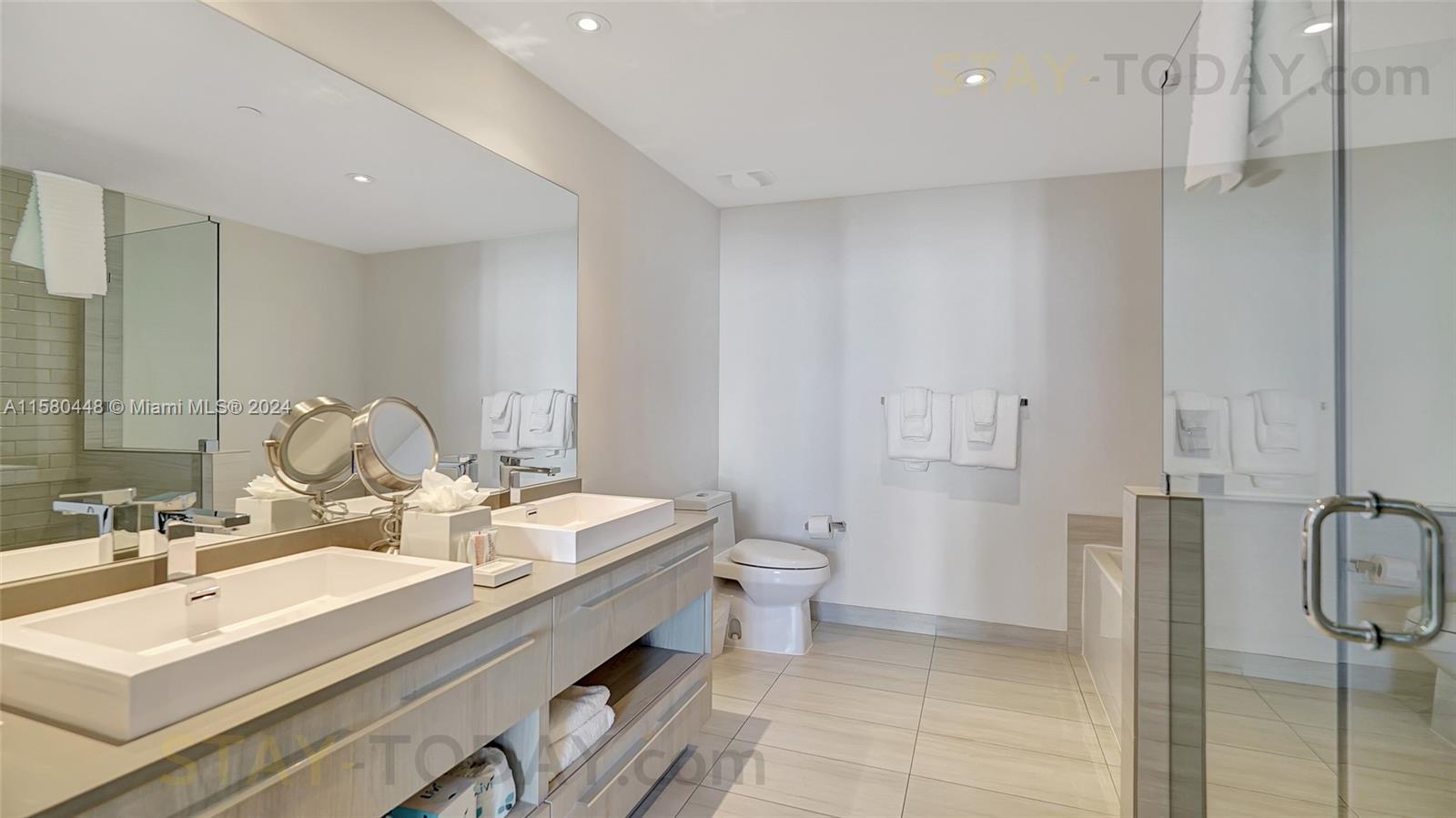 4010 South Ocean Drive, Unit R805 Hollywood, FL 33019 - Photo 20 of 36 a bathroom with a double vanity sink mirror and toilet