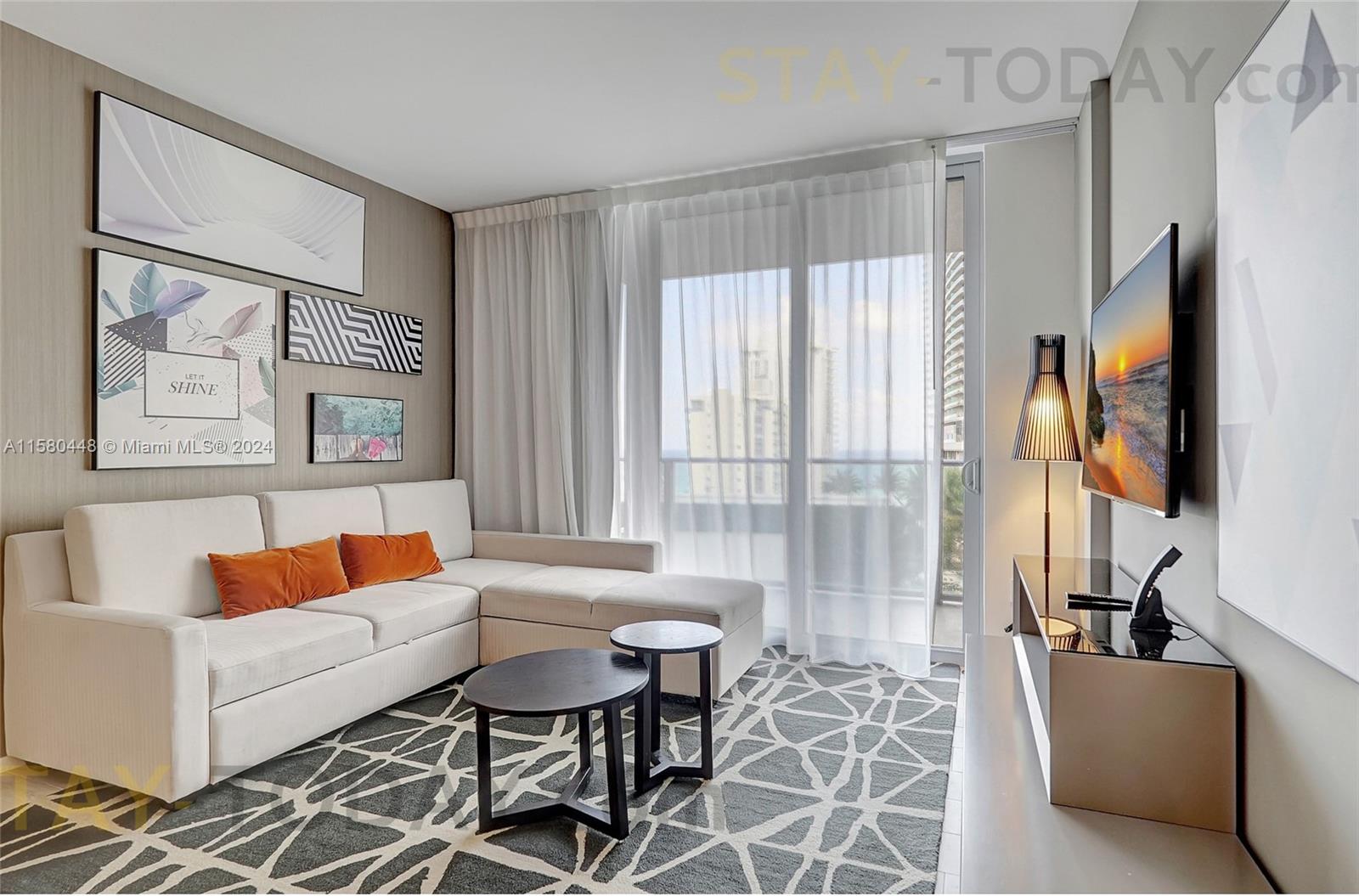 4010 South Ocean Drive, Unit R805 Hollywood, FL 33019 - Photo 2 of 36 a living room with furniture and a flat screen tv