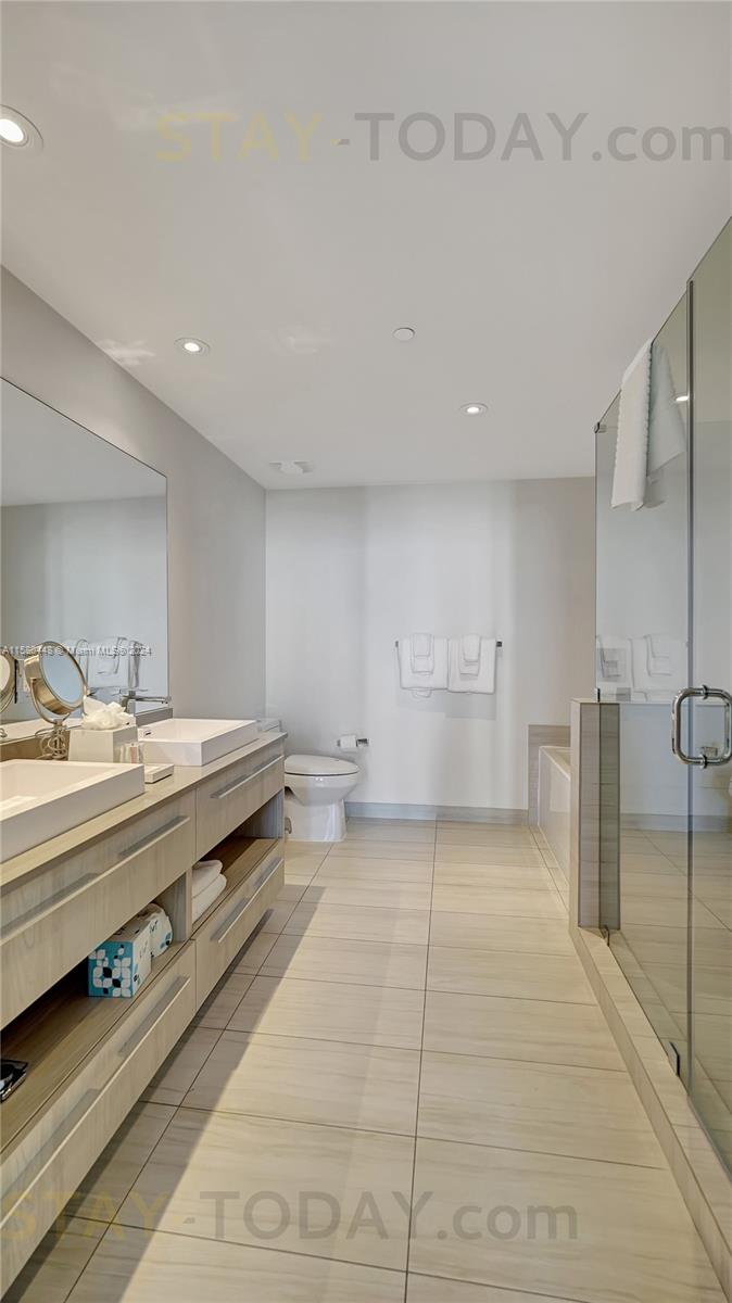 4010 South Ocean Drive, Unit R805 Hollywood, FL 33019 - Photo 21 of 36 a large white room with a large mirror and a sink