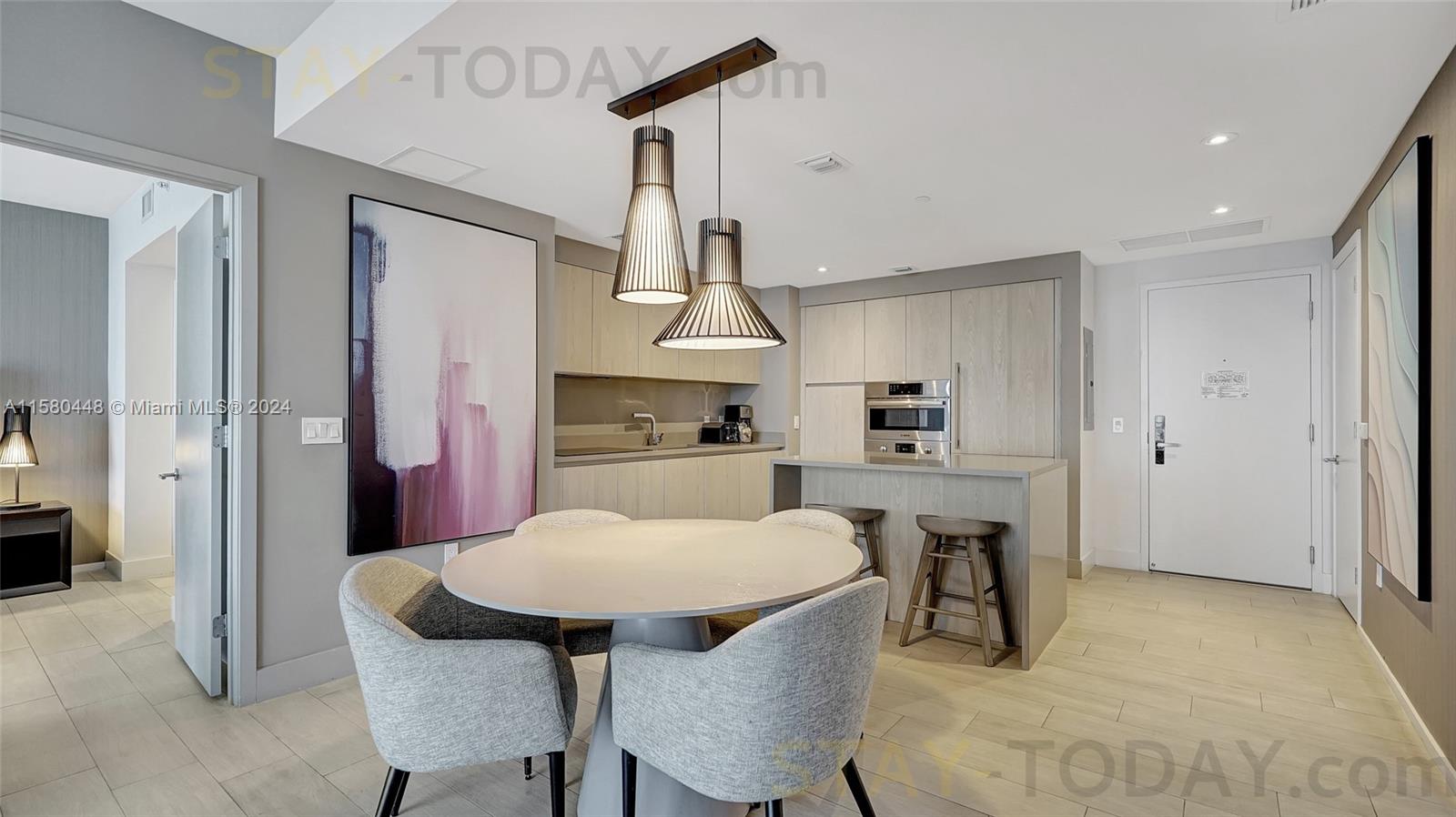 4010 South Ocean Drive, Unit R805 Hollywood, FL 33019 - Photo 6 of 36 a kitchen with stainless steel appliances a dining table chairs and a refrigerator