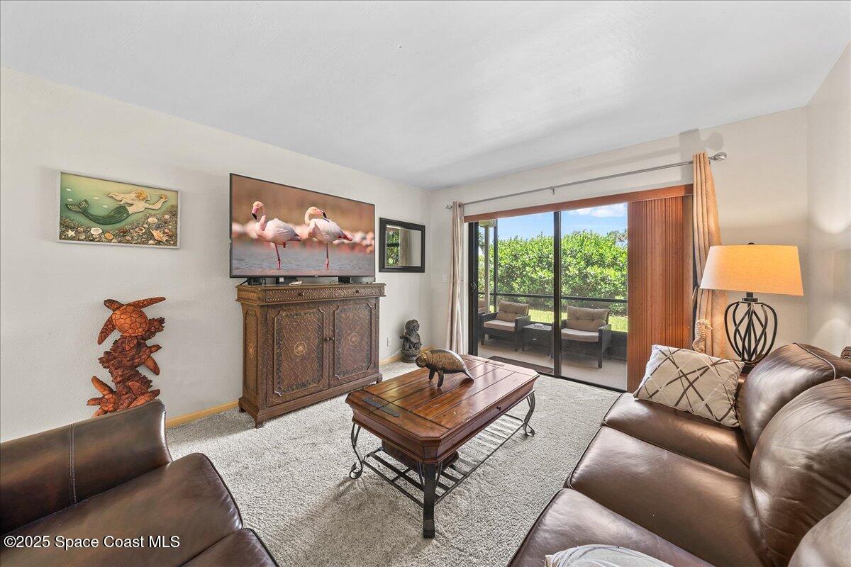 1700 South Atlantic Avenue, Unit 104 Cocoa Beach, FL 32931 - Photo 13 of 55 a living room with furniture and a flat screen tv