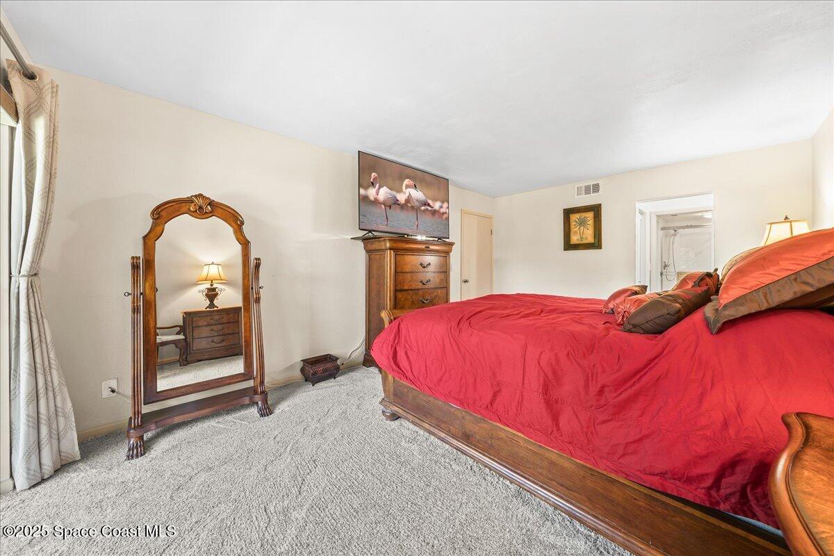 1700 South Atlantic Avenue, Unit 104 Cocoa Beach, FL 32931 - Photo 15 of 55 a bedroom with a bed and a mirror