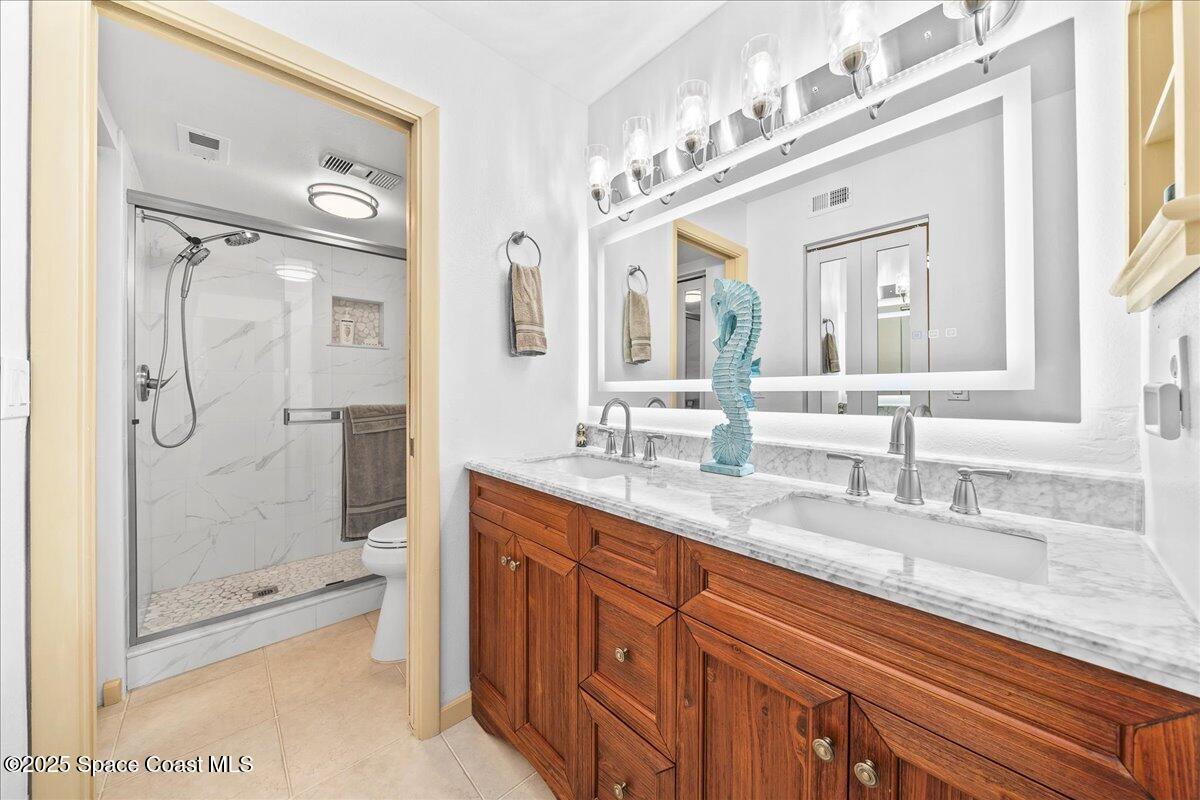 1700 South Atlantic Avenue, Unit 104 Cocoa Beach, FL 32931 - Photo 16 of 55 a bathroom with a granite countertop sink mirror and shower
