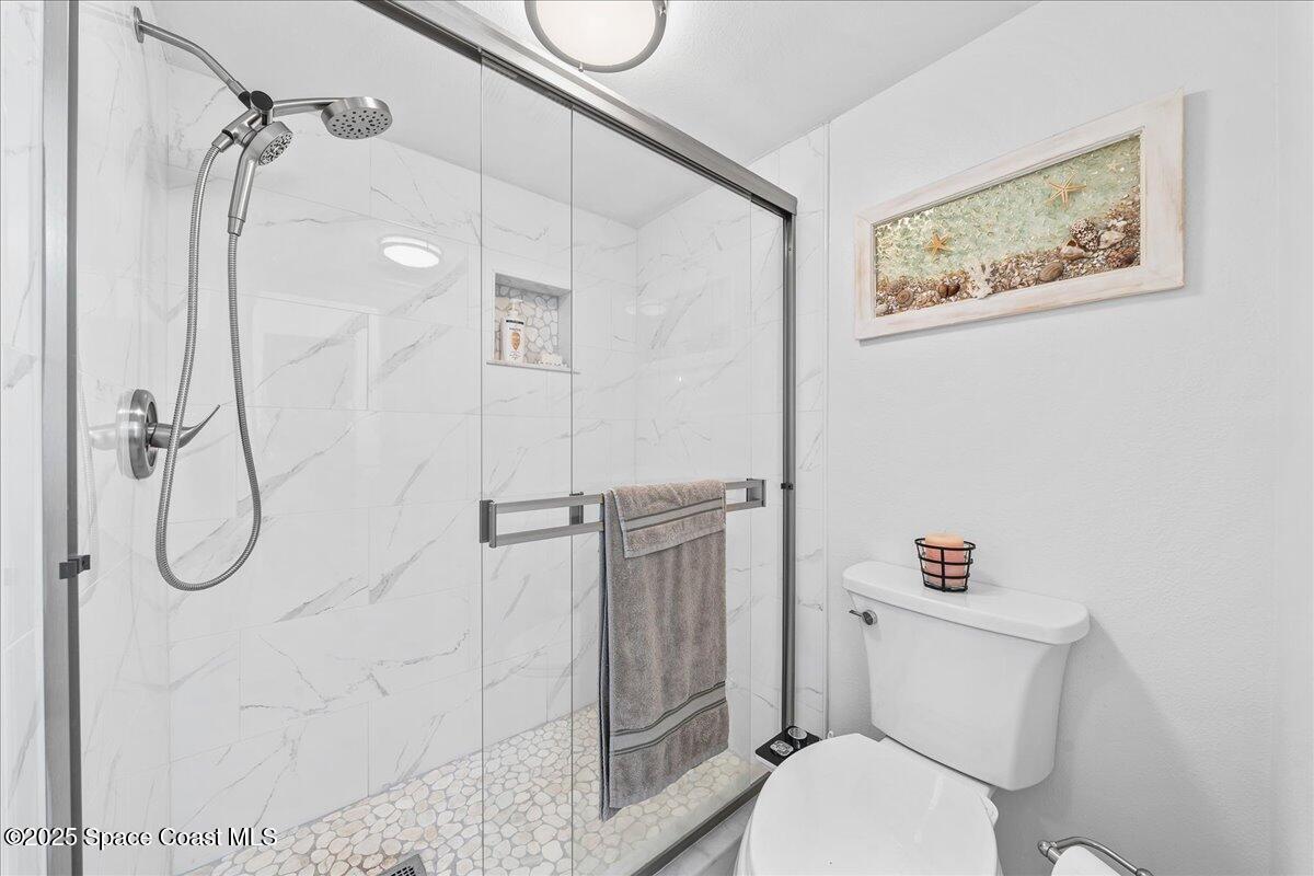 1700 South Atlantic Avenue, Unit 104 Cocoa Beach, FL 32931 - Photo 17 of 55 a white toilet sitting next to a bathroom sink