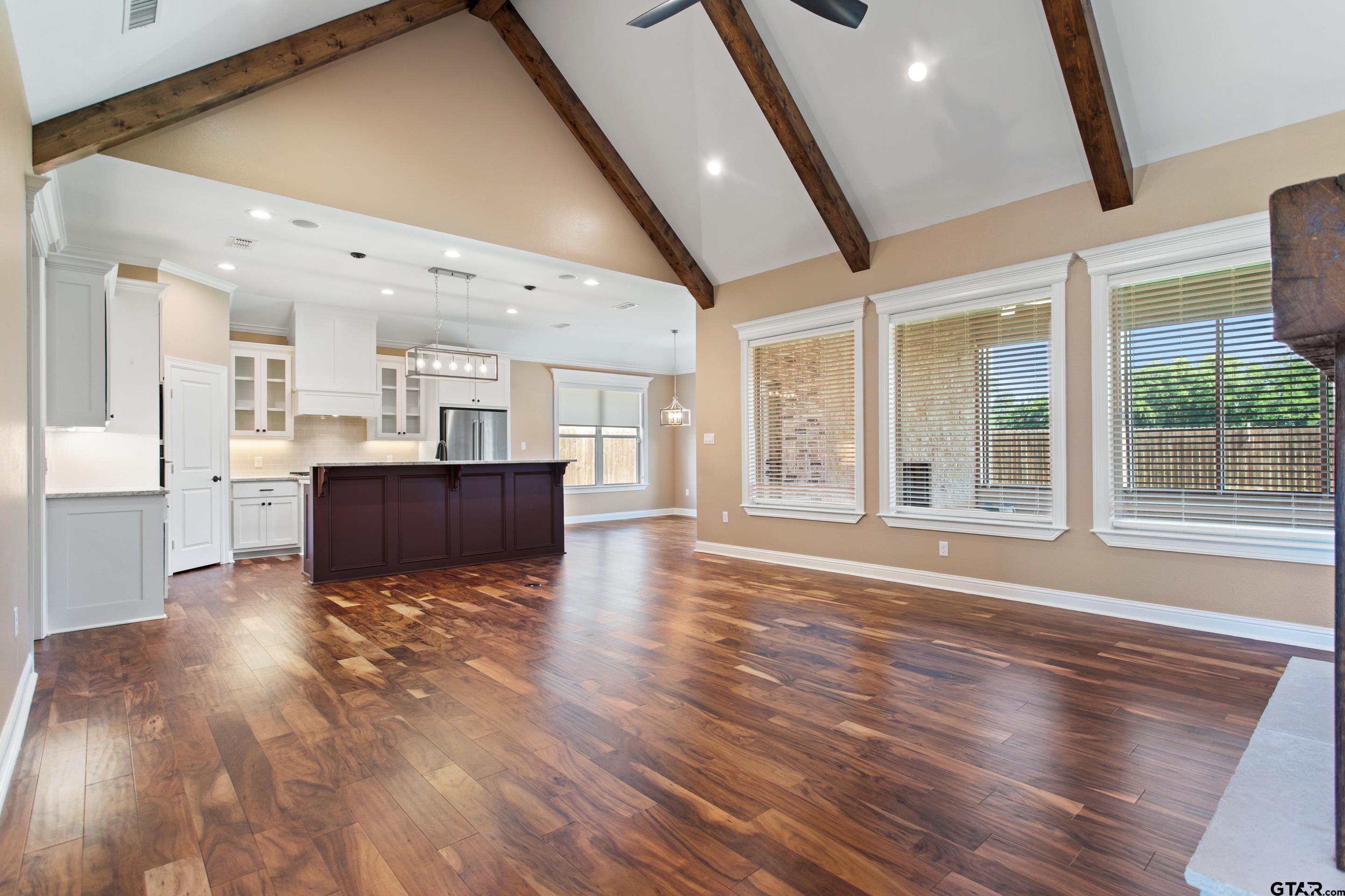 105 Nathan Road Chandler, TX 75758 - Photo 5 of 36 a view of an empty room with wooden floor and a kitchen