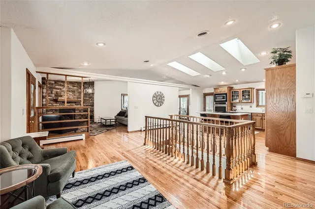 a living room with furniture a wooden floor and white walls