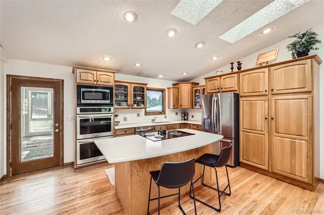 a kitchen with stainless steel appliances a refrigerator and a stove top oven