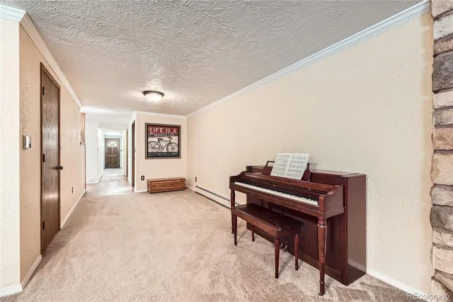 a view of a hallway with wooden floor and a piano