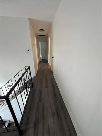 a view of a hallway with wooden floor and staircase