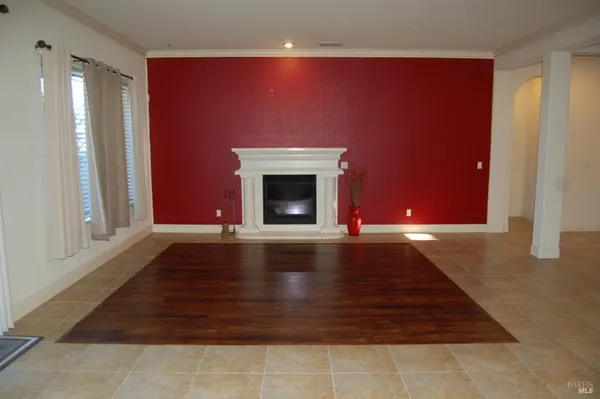 a view of empty room with fireplace and wooden floor
