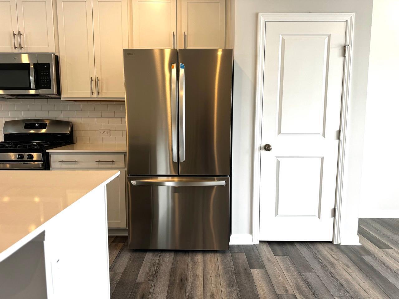 168 Aster Bloom Lane Raleigh, NC 27610 - Photo 16 of 38 a view of a kitchen with wooden floor and electronic appliances